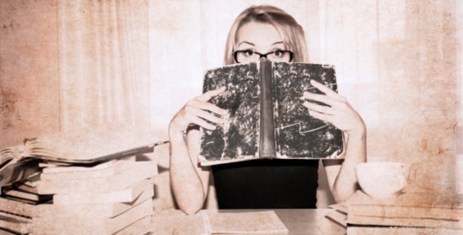 nell'immagine una ragazza con un libro davanti al volto: concept social network conoscenza studio apprendere