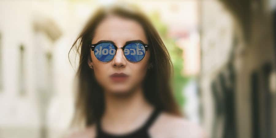 Competenze digitali a Binario F from Facebook: nell'immagine si vede una ragazza sui cui occhiali si riflette il logo del social network