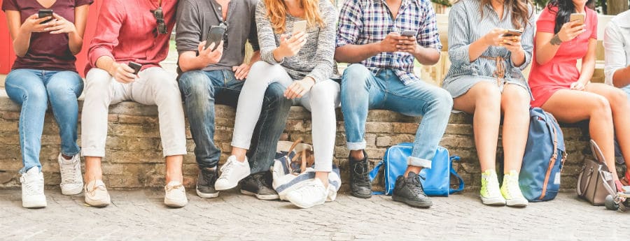 Gruppo di adolescenti intenti a guardare il proprio smartphone
